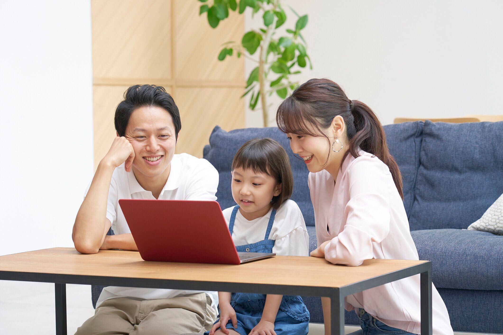 自宅でラップトップを使用してアジアの家族