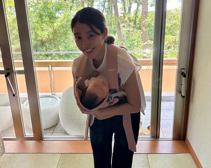 抱っこひもで娘さんを抱っこする岡副さん。