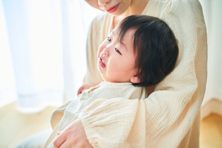 泣いている乳児を抱く母親