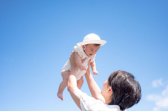 赤ちゃんと母親と美しい青い空
