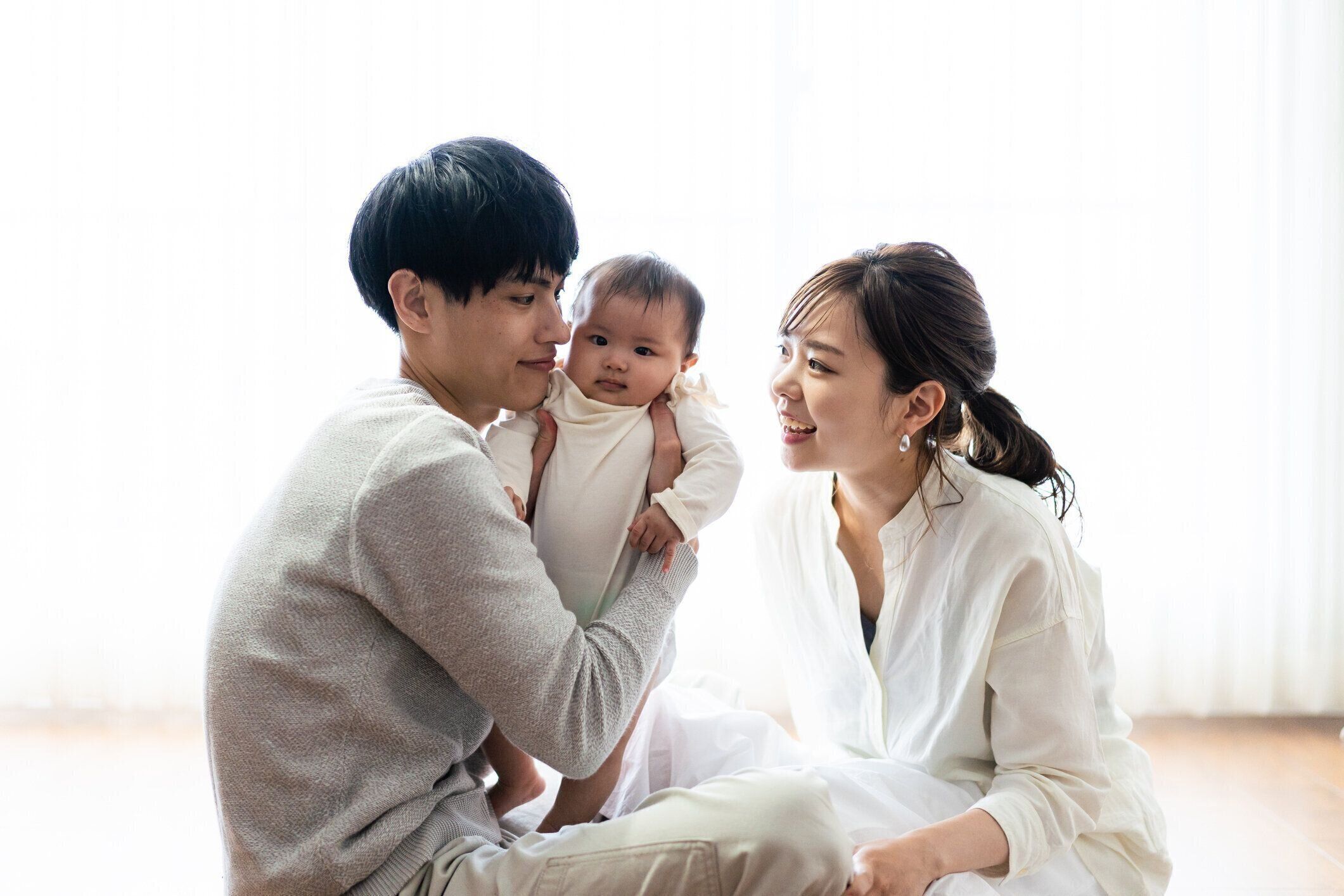 赤ちゃんを抱っこするお母さんとお父さん