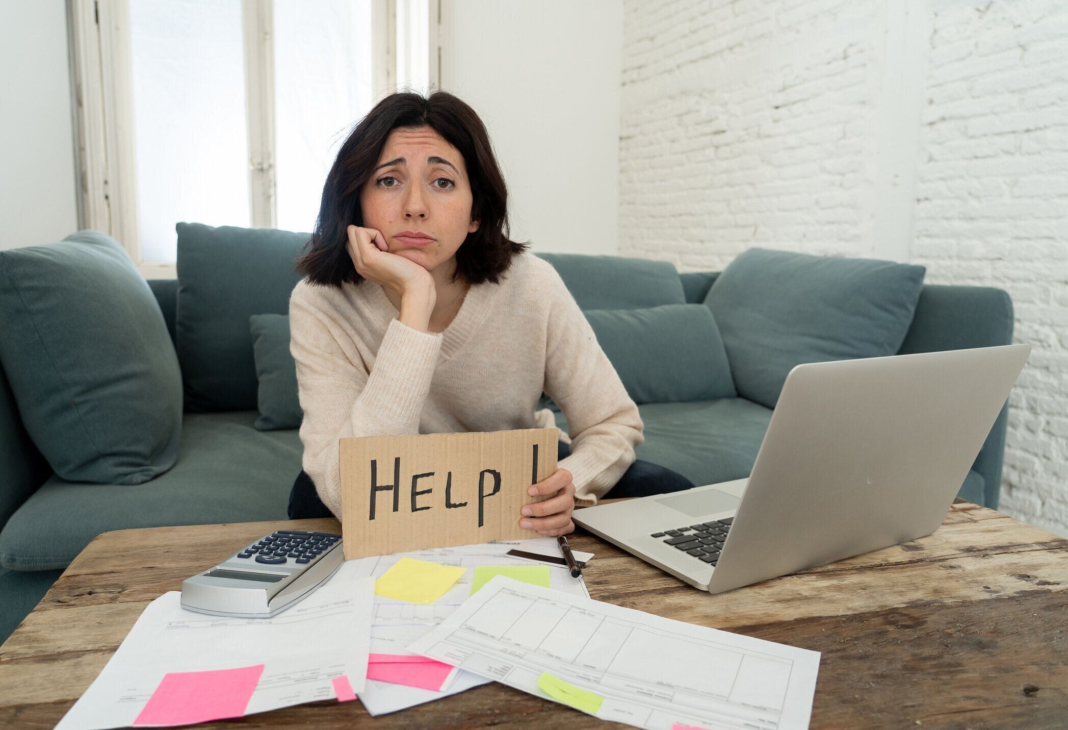 心配している若い女性の肖像画は、ノートパソコンで手形、借金、税金費用、会計の家の財政を支払うのに助けを求めてストレスと絶望的な感じ。オンラインバンキングと金融問題で。