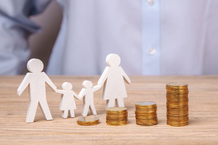 ご家族の予算の成長。男がコインのスタックの背景に彼の父、母、娘と息子から家族を保持します。