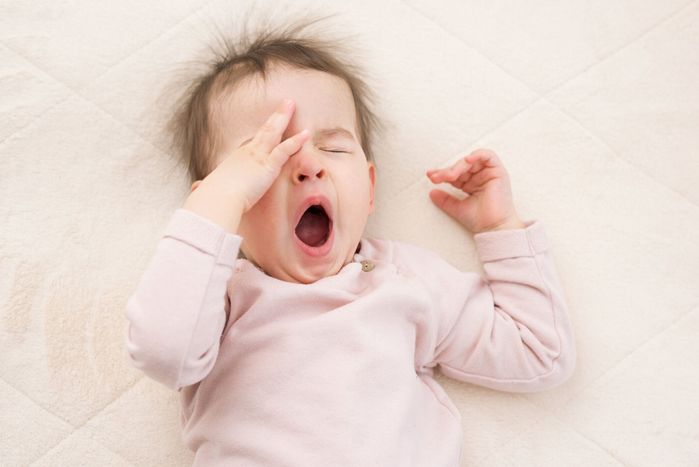 美しい睡眠の肖像画、あくび赤ちゃん幼児ベッドを着てピンクのプルオーバー。 就寝。保育園