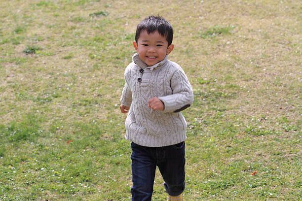 日本の男の子のランニング、草の上で