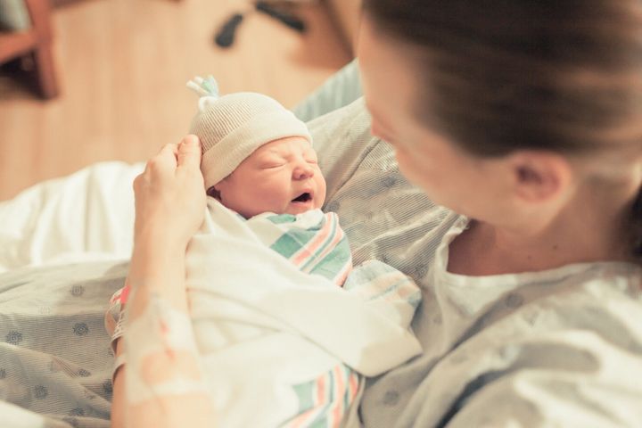 病院で彼女の生まれたばかりの赤ちゃんを持つお母さん