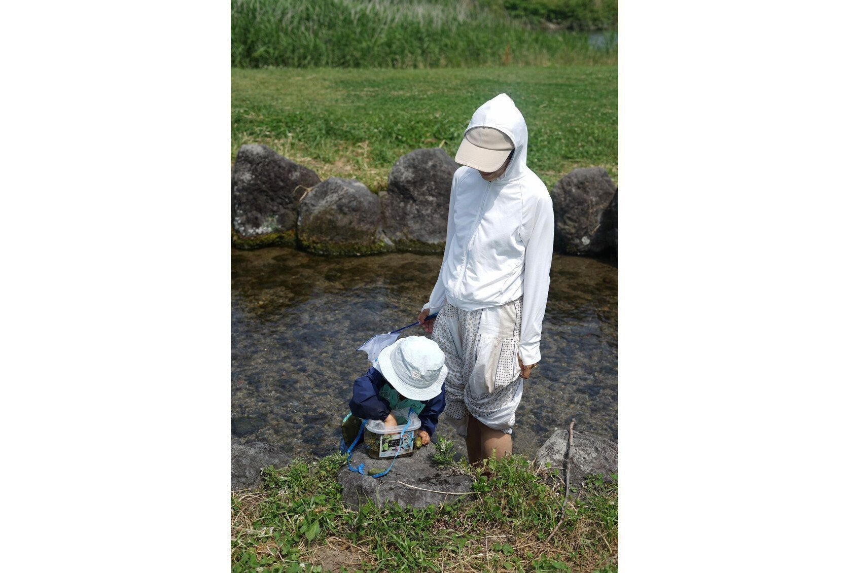 川遊びをする、竹内さんと息子さん。週末には家族で公園へ。