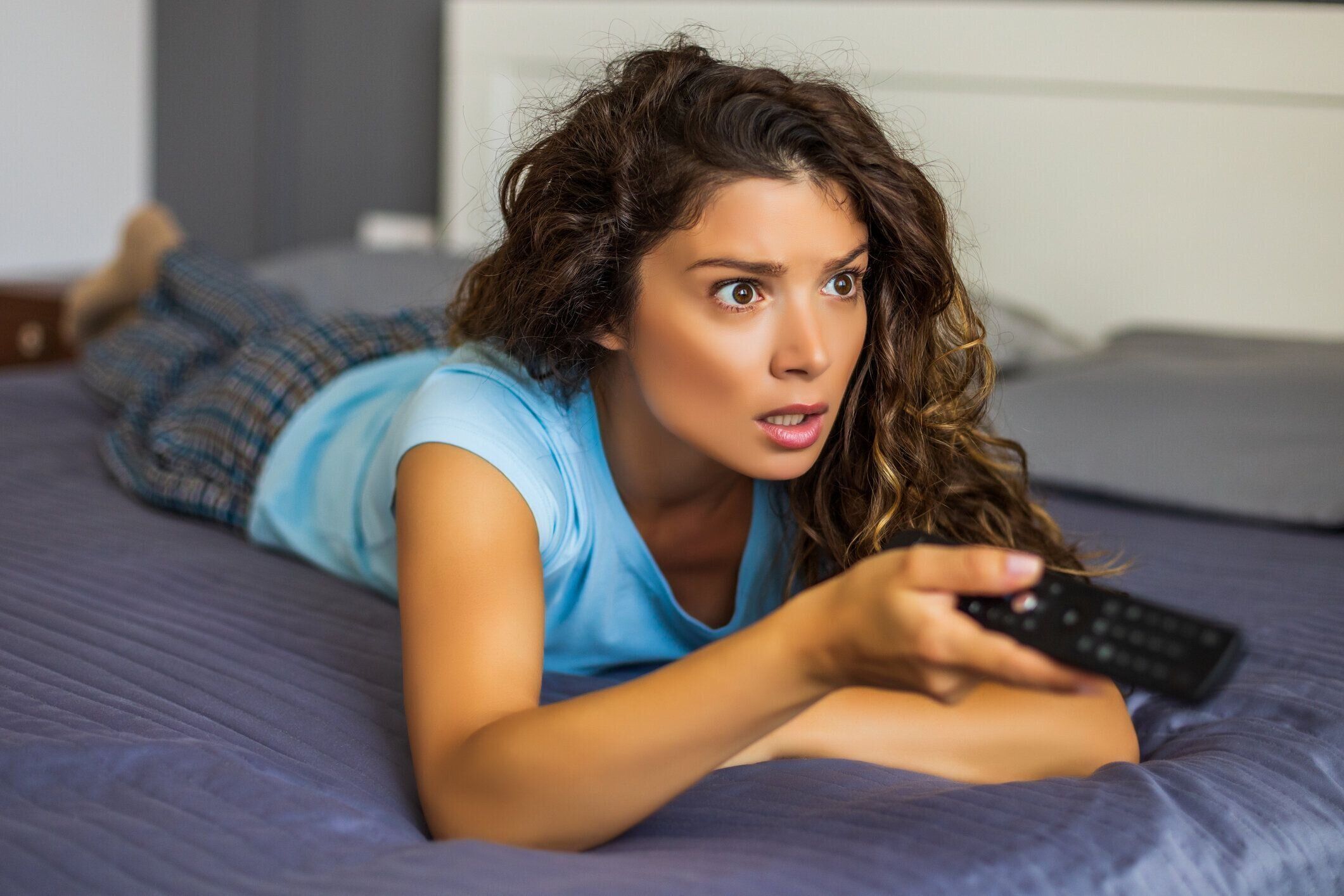 女性はテレビで何かを見て、彼女はショックを受けています