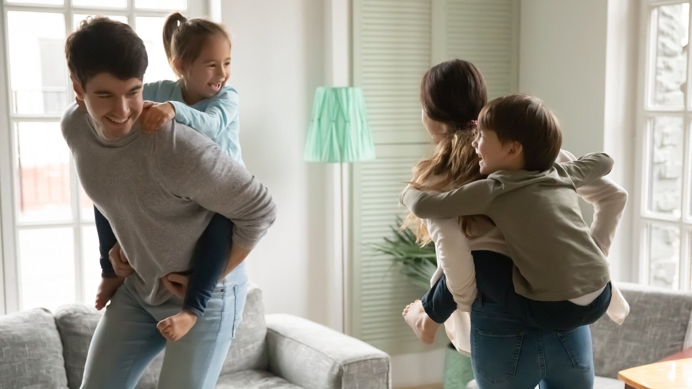 小さな子供たちは家で若い両親と遊ぶ