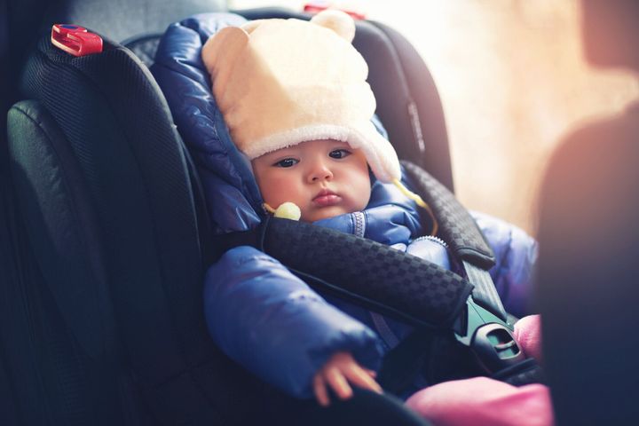 冬の服を着て車の中に座っている愛らしい小さな女の子