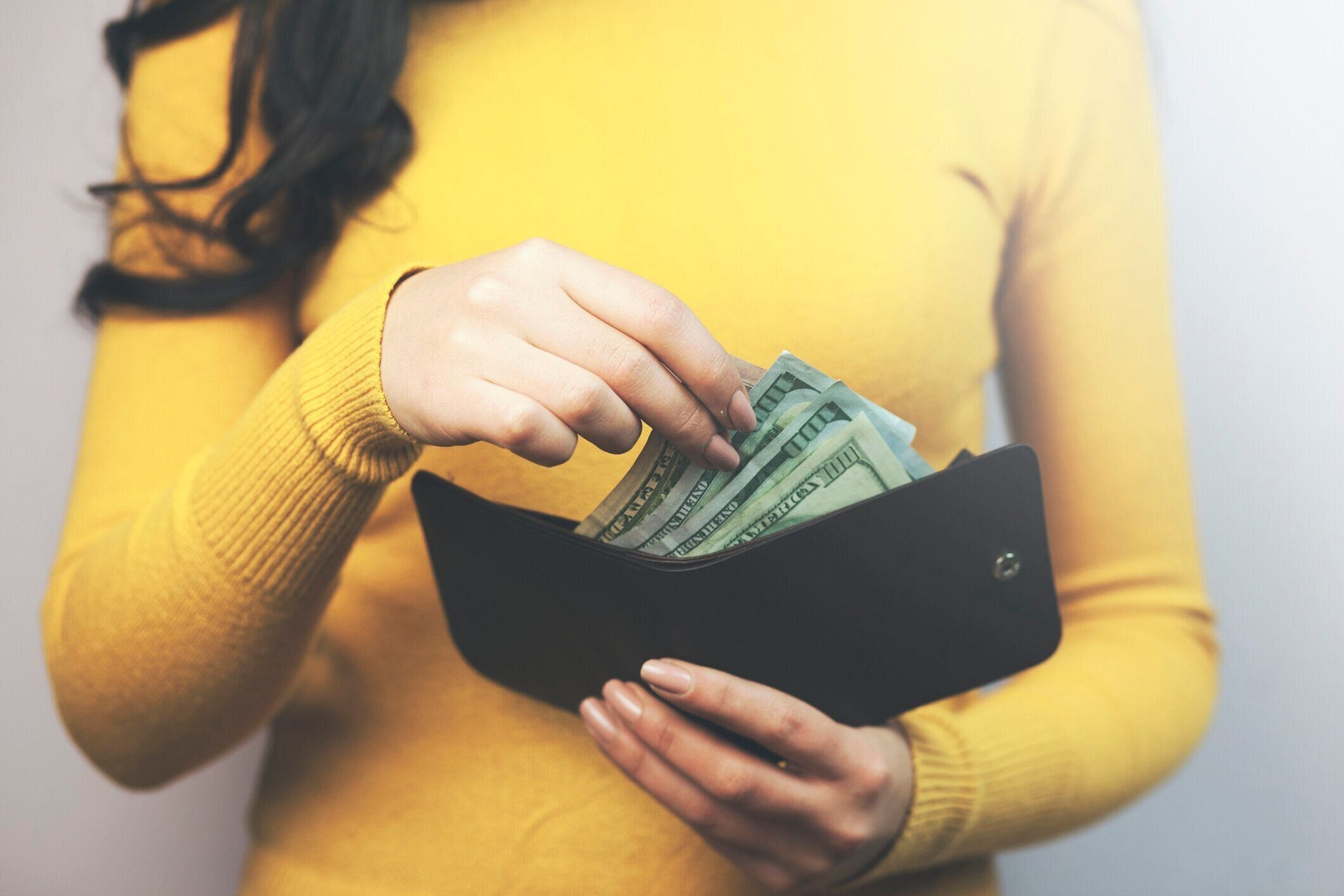 女性の手の財布とお金