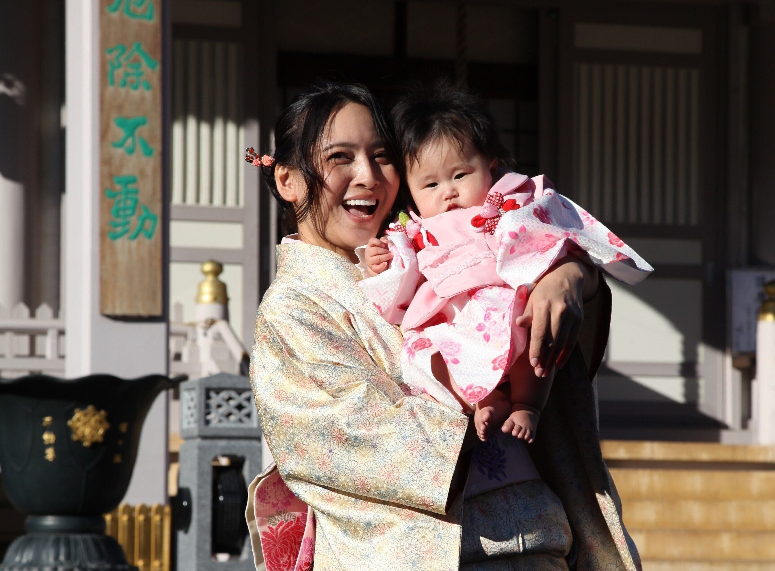 二女をうれしそうに抱っこする加藤さん。お宮参りでの1枚。