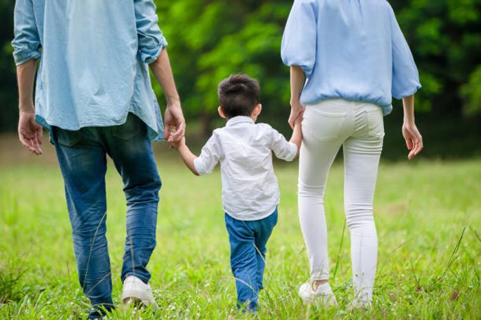 子供と一緒に歩く若い両親