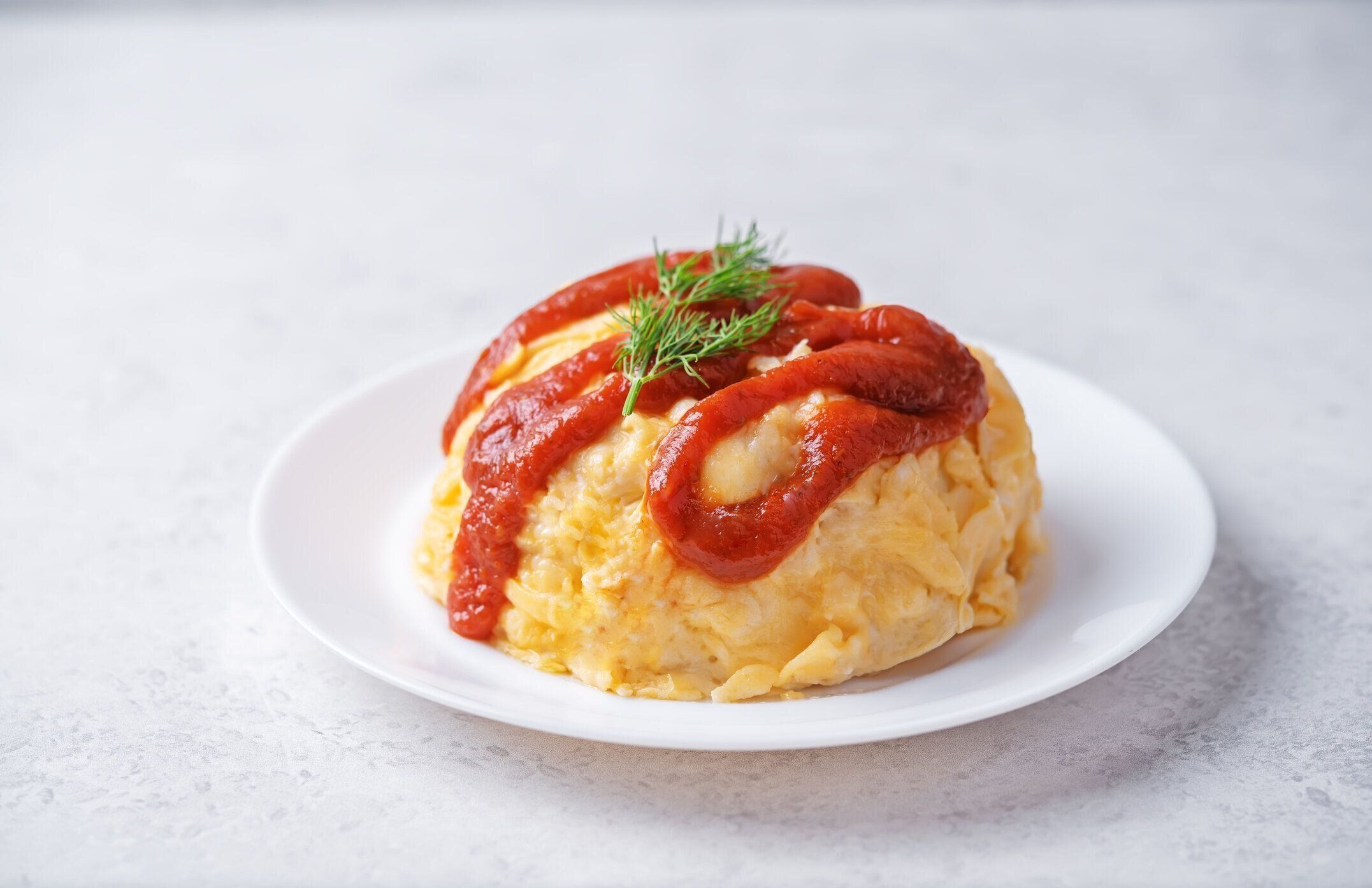 オムライスとケチャップソースを皿に