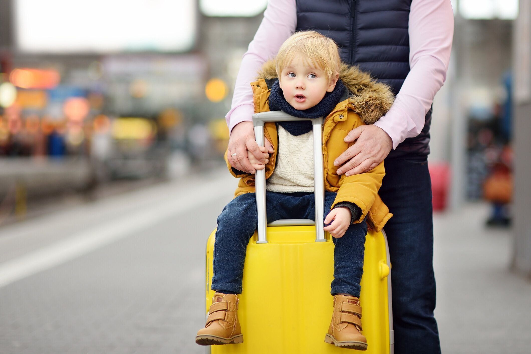 笑みを浮かべて少年と彼の父親は鉄道駅プラットフォームを急行列車を待っています。