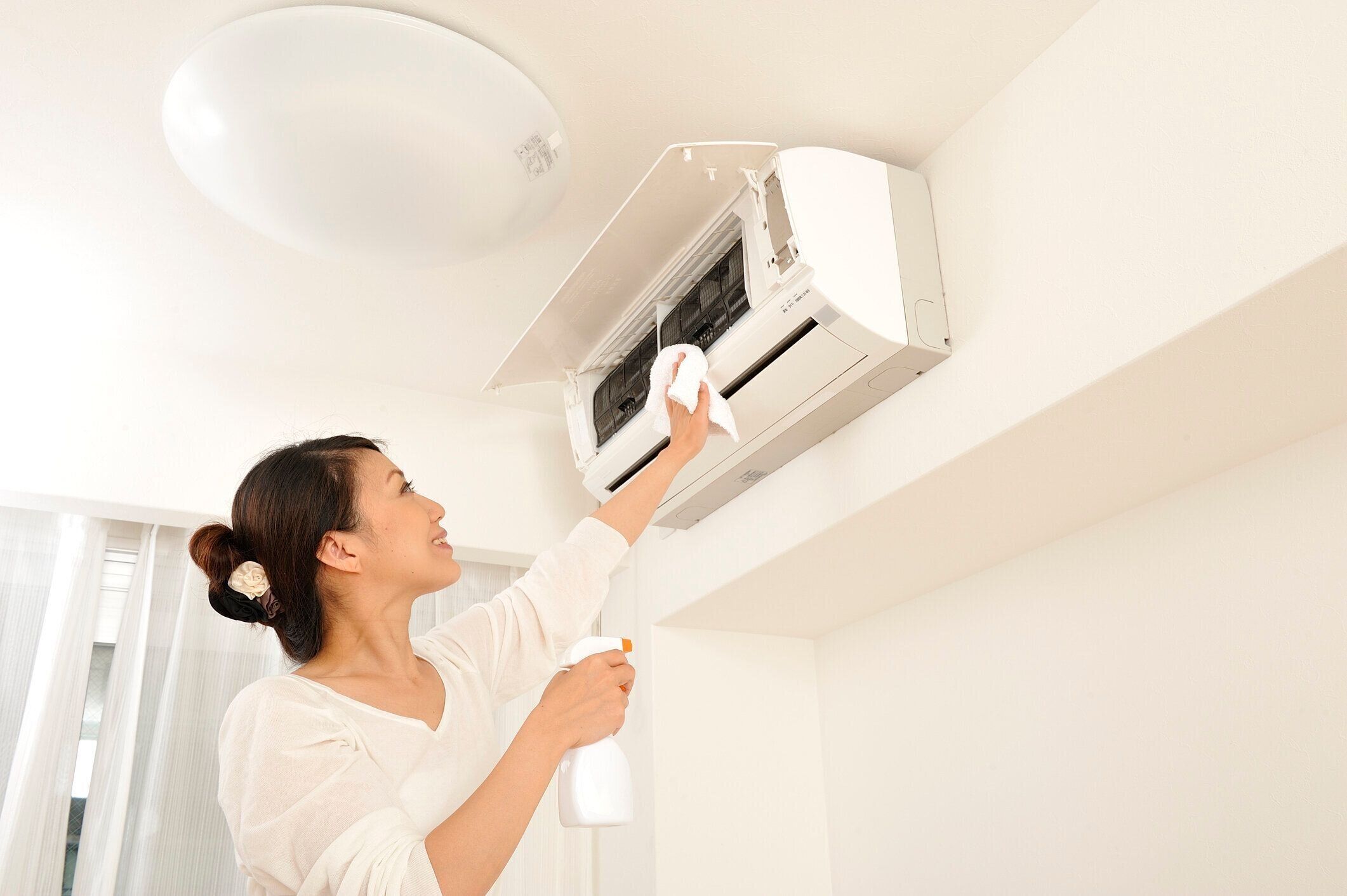 エアコンを掃除する日本人女性