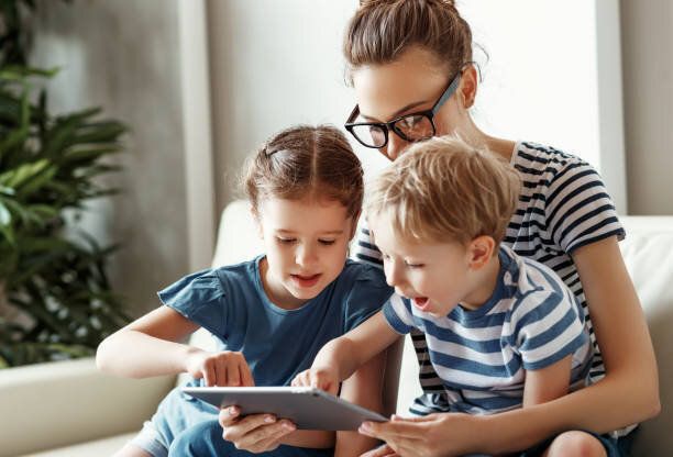 自宅でタブレットを使用して子供と幸せな女性