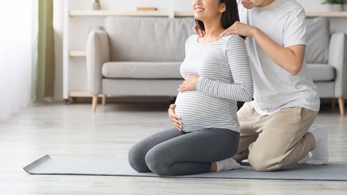 彼の妊娠中の妻の肩をこすり認識できない男