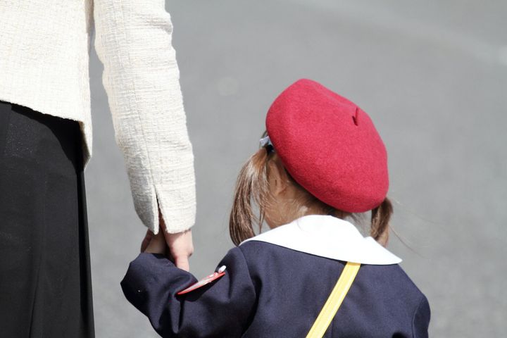 (3 歳まで) (後ろ姿) 彼女の母の手を握り締めて幼稚園制服を着た日本人の女の子