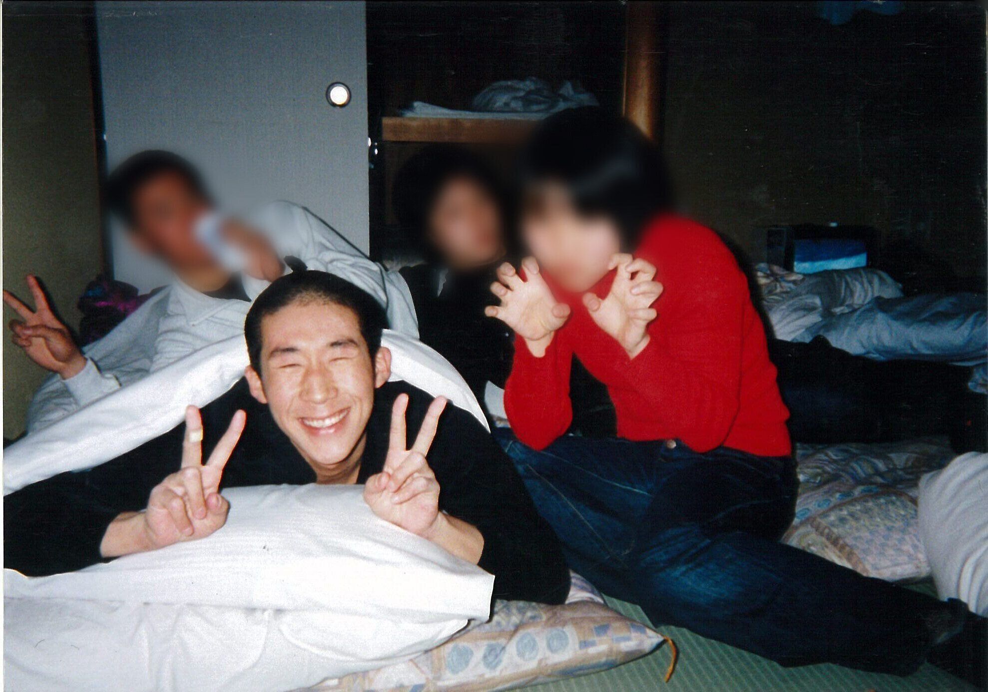 手前左でピースサインをする、学生時代の田村さん。