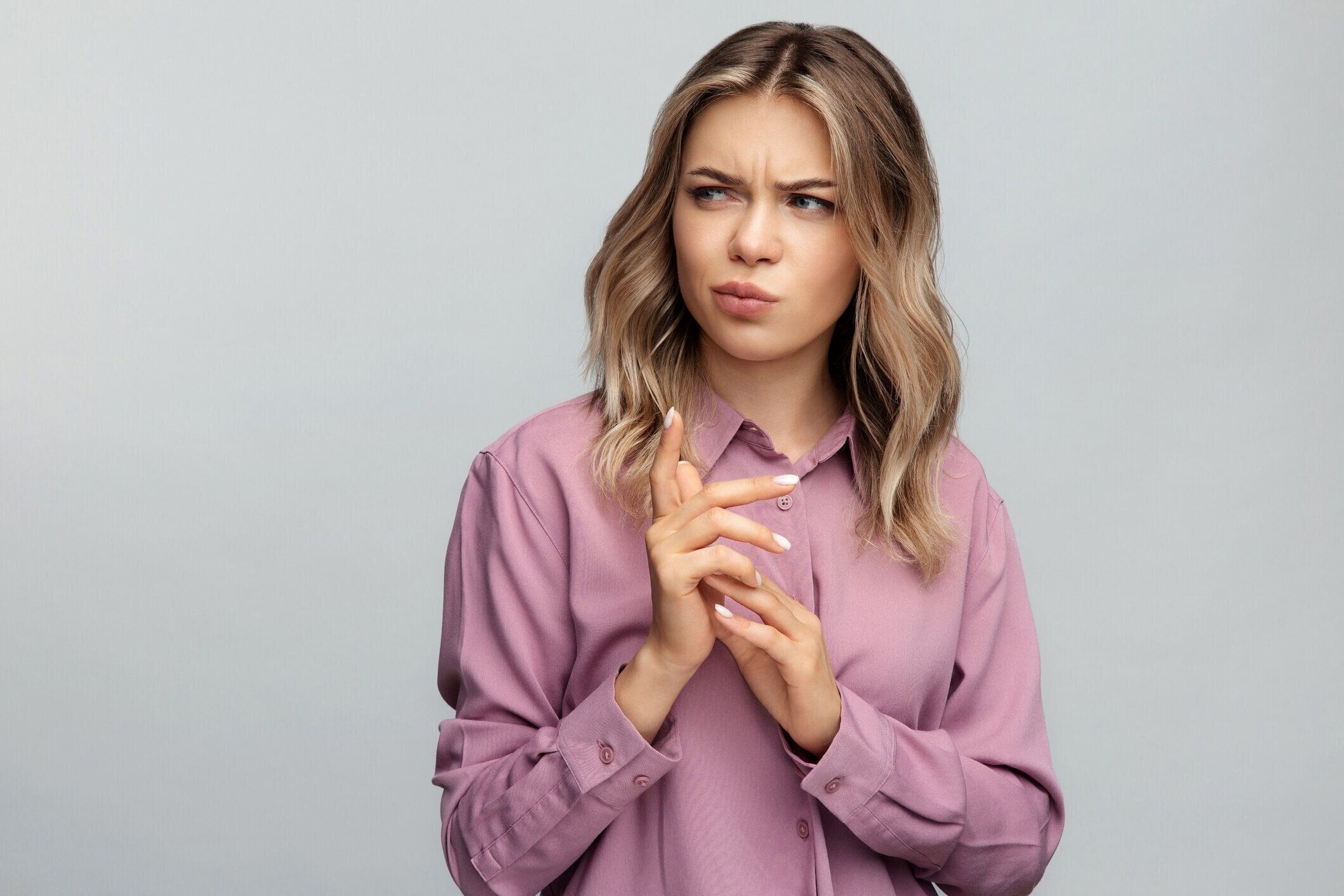 混乱した若い女性は疑わしいと疑わしい感情思慮深い曲げ指で脇に見える