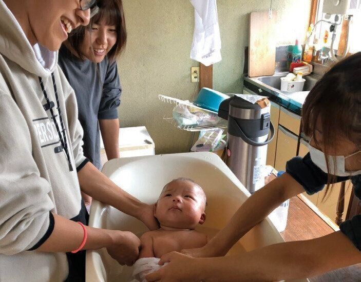 0歳代の赤ちゃんの沐浴の様子、台所を使っての沐浴も。