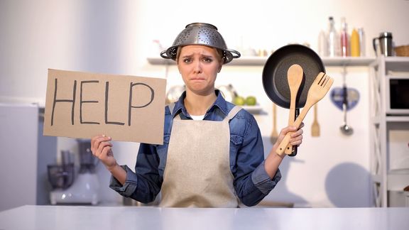経験の浅い主婦は、料理の助けを求めて、頭の上にポットを着用し、冗談