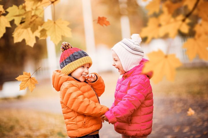 美しい秋の日に葉を投げる子供たち