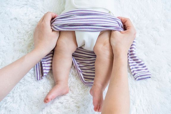 【かぶるタイプの肌着・ウエア お着換えのコツ・1】ねんねしている場合は、足側から着せる