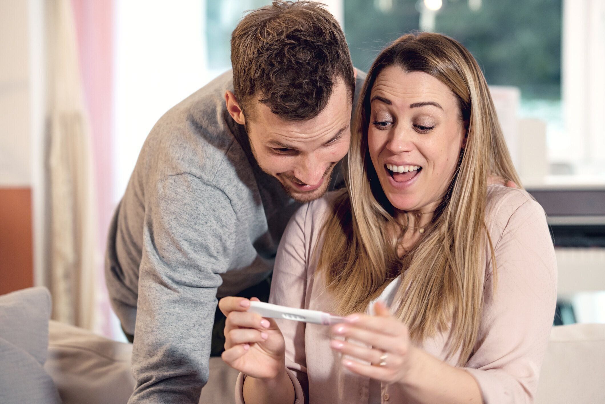 妊娠検査結果を待って、肯定的な結果の後に祝う幸せな若いカップル