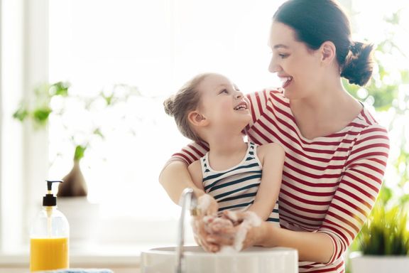 女の子と彼女の母親は手を洗っています