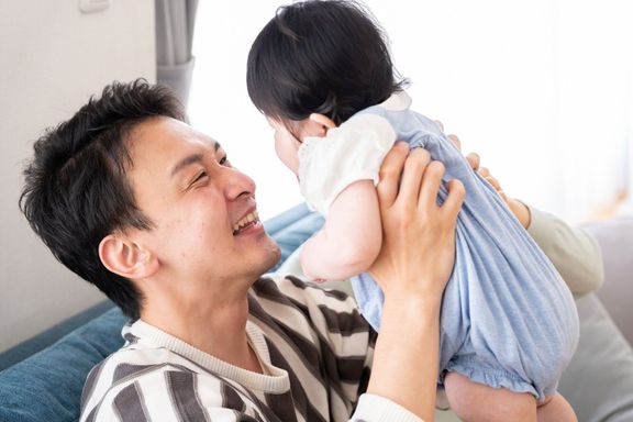 若いアジア家族のソファーでリラックス