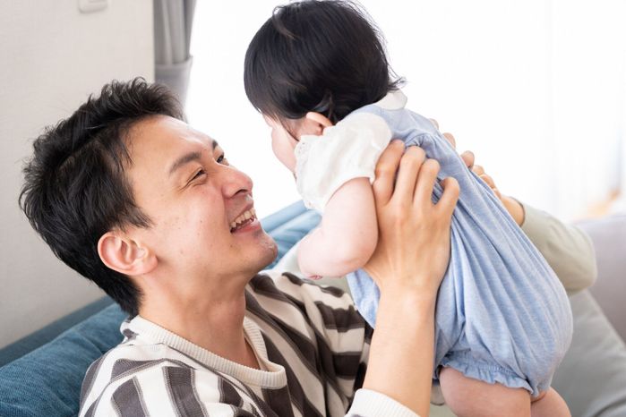 若いアジア家族のソファーでリラックス