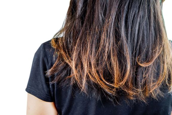 女性は白い背景に分離された髪の割れ目の端を損傷