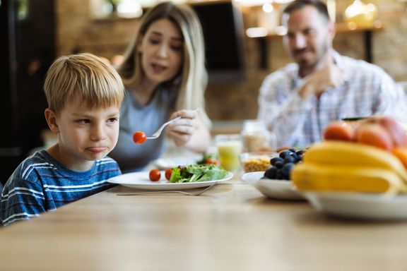 野菜を食べることを拒否する不幸な小さな男の子