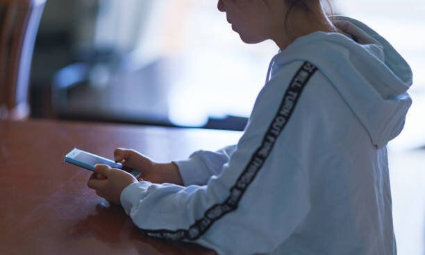 自宅でモバイルゲームをしている日本の女の子