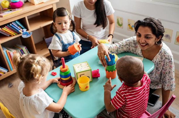 保育園子供たちが教室で先生と遊んで