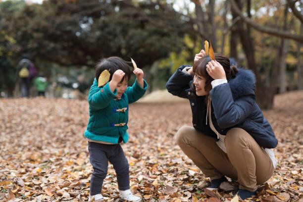 母と彼女の息子は、紅葉のフィールドで踊っています。