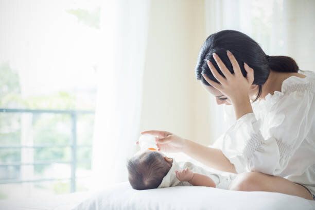 妊娠中のうつ病から苦しんでベッドの中で新生児にフォーミュラミルクのアジアの母保育園給餌ボトル。ヘルスケアシングルママ母性ストレスの概念.