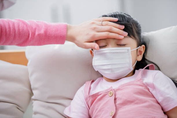 ママは彼女の熱をチェックする子供に触れる