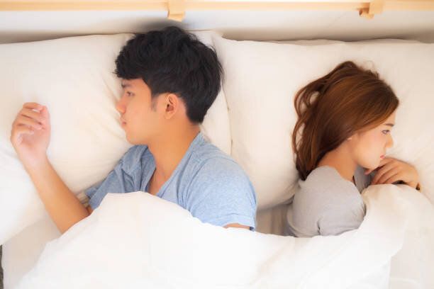 若いアジアのカップルは、自宅でベッドの上で別々に横たわって失敗し、問題の紛争と離婚を持つアジアの家族、男女の不幸とストレスとの関係、ライフスタイルの概念、トップビュー。
