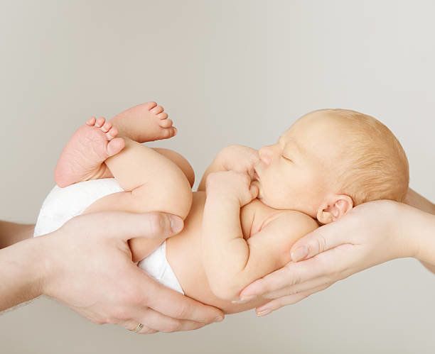 生まれたばかりの赤ちゃんのベッドでご両親に手、お子様やご家族のコンセプト