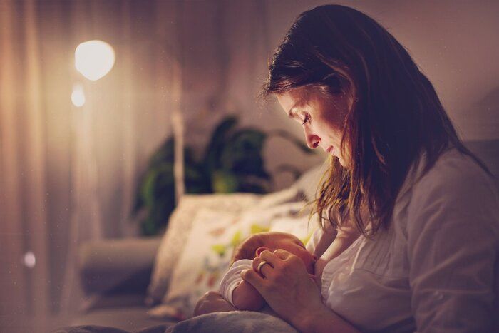 美しい母親、母乳、夜彼女の生まれたばかりの赤ちゃんの男の子