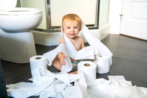 幼児がトイレでトイレット ペーパーを裂く