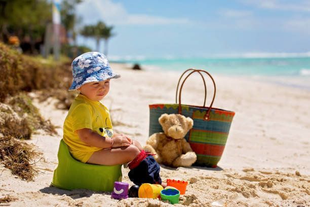 小さな幼児の少年、熱帯の島のビーチでトイレのトレーニングを学びます