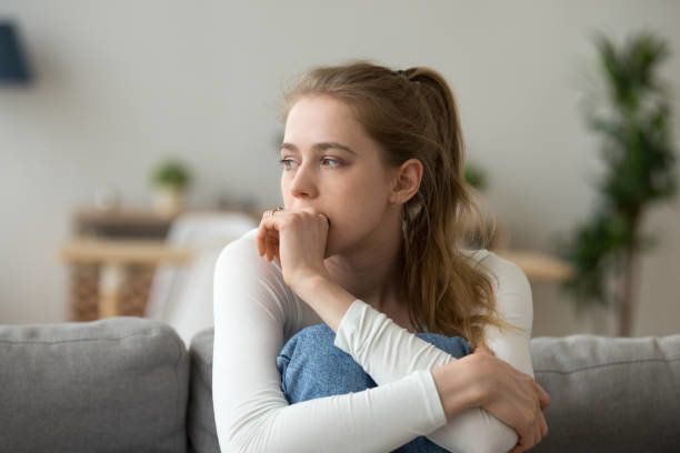 家で一人でソファに座って悲しい女