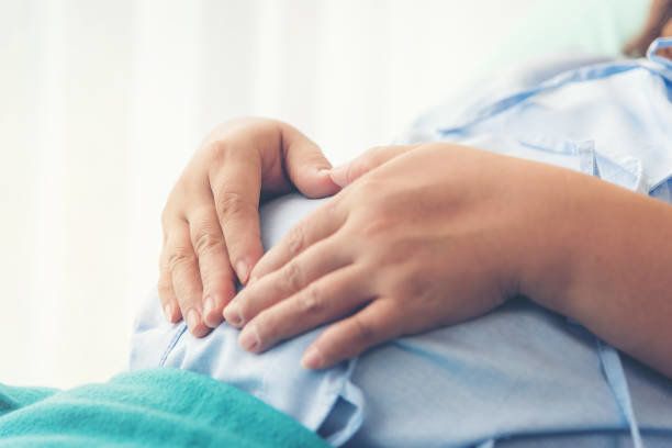 病院で出産するのを待っているベッドの上に横たわっている妊婦。