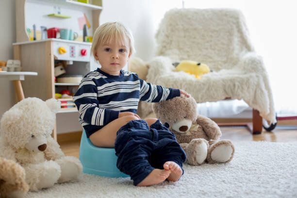 かわいい幼児の男の子、トイレのトレーニング、彼のテディベアで遊ぶ