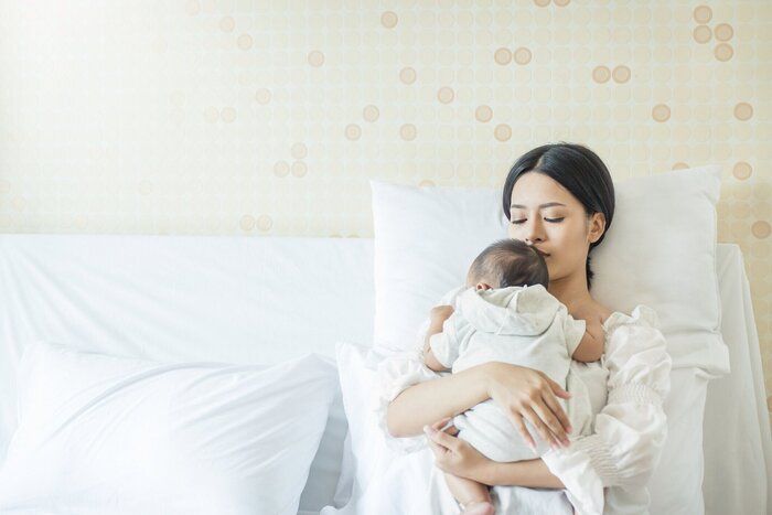 生まれたばかりの赤ちゃんと美しい若いアジアの母の肖像画を間近します。