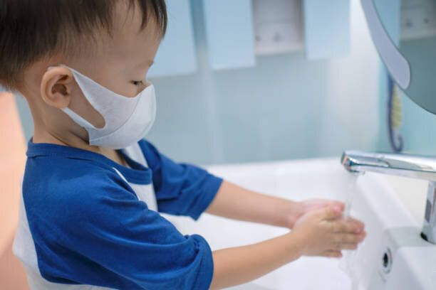 アジアの3 - 4歳の幼児の男の子は、子供のための公衆トイレ/バスルームの流しに自分で手を洗う保護医療マスクを着用 - ソフト&選択的な焦点